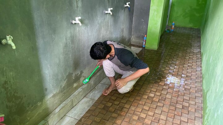 Satu Relawan Pemuda Sedang Fokus Membersihkan Area Tempat Wudhu Masjid Sebagai Bagian Dari Aksi Sosial Geber MasjidMu AMM Piyaman.